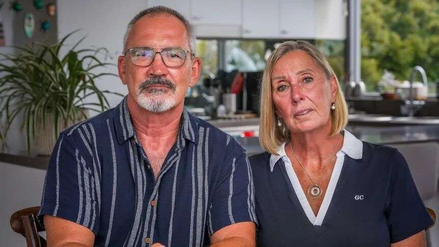 A man and woman sit side by side at a table.