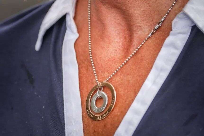 A necklace hangs around a woman's neck.